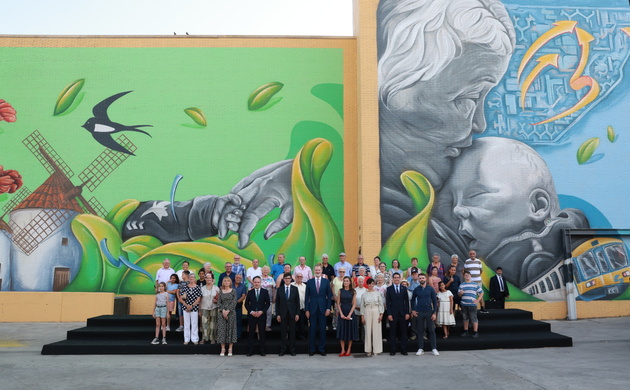 Fotografía de grupo de Sus Majetades los Reyes con una representación debadienses frente al mural participativo que rinde homenaje a Badia del Vallès