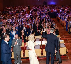 Su Majestad el Rey es recibido entre aplausos al entrar al auditorio