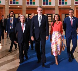 Sus Majestades los Reyes, a su llegada al Palacio de Exposiciones y Congresos de Sevilla (FIBES), acompañados por el secretario general de Naciones Un