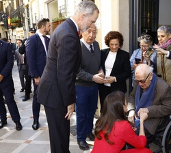 Sus Majestades los Reyes conversan con una persona durante su recorrido a pie por las calles de Jaén