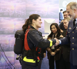 Su Majestad el Rey saluda a una de las participantes en una demostración contraincendios