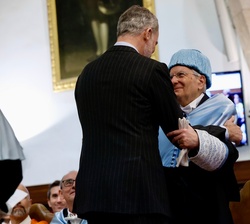 El Rey da el abrazo académico al nuevo doctor; en el momento del juramento