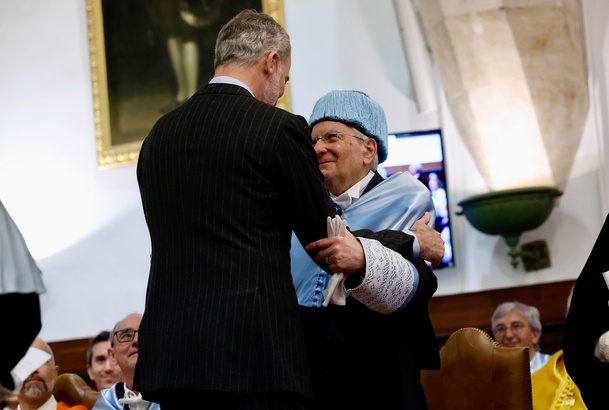 El Rey da el abrazo académico al nuevo doctor; en el momento del juramento