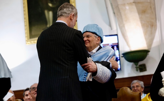 El Rey da el abrazo académico al nuevo doctor; en el momento del juramento