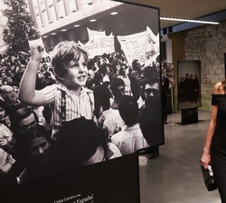 Su Majestad la Reina contempla una de las fotografías de la exposición