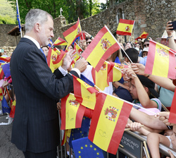 Su Majestad el Rey firma banderas a un grupo de niños