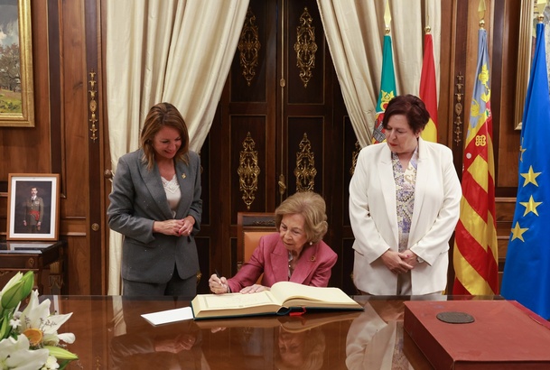 Momento de la firma de Su Majestad la Reina Doña Sofía en el libro de honor