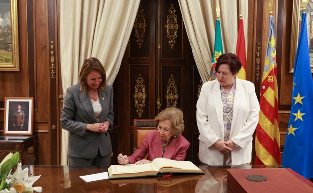 Momento de la firma de Su Majestad la Reina Doña Sofía en el libro de honor