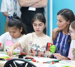 Unas alumnas de 6º curso de primaria explican a Doña Letizia el proceso que realizan en el taller de exlibris