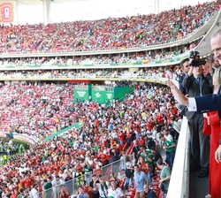 Su Majestad el Rey saluda al público a su llegada al palco de autoridades en el Estadio Akron 