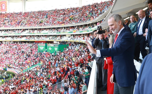 Su Majestad el Rey saluda al público a su llegada al palco de autoridades en el Estadio Akron 