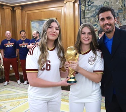 SS.AA.RR. la Princesa de Asturias y la Infanta Sofía junto al capitán de la Selección Española, Rodrigo Hernández y el trofeo de la "Copa Mundial