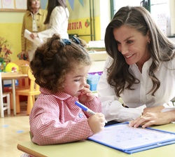 Su Majestad la Reina observa como le hace un dibujo una de las alumnas de 1º infantil