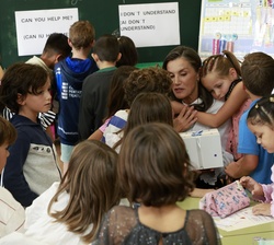 Doña Letizia recibe un cariñoso abrazo de una de las alumnas durante su visita al aula de 2º de primaria en el C.P. Gesta