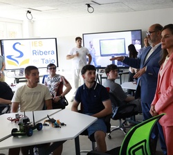 Su Majestad la Reina en la sala multiusos junto a los alumnos que trabajan sobre robótica e IA