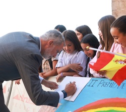 El Rey firma uno de los murales realizados por unos niños a su llegada al Convento de la Merced