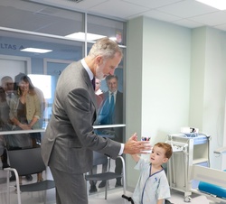 Don Felipe saluda a un niño durante su recorrido por el hospital