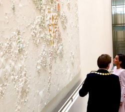 Sus Majestades los Reyes junto al alcalde observa un mural del ayuntamiento