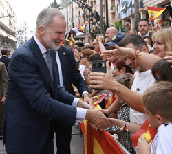 Su Majestad el Rey saluda a un niño momentos antes de entrar en el Ayuntamiento