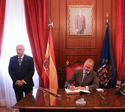 El Rey firma en el libro de honor de la Ciudad Autónoma de Melilla durante su visita al Palacio de la Asamblea