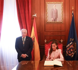 Doña Letizia firma en el libro de honor de la Ciudad Autónoma de Melilla durante su visita al Palacio de la Asamblea