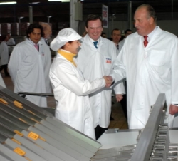 El Rey saluda a una trabajadora de la fábrica durante su recorrido por las instalaciones