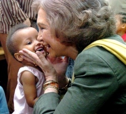 Doña Sofía besa a una niña en el Centro de Emergencia Infantil de Praia