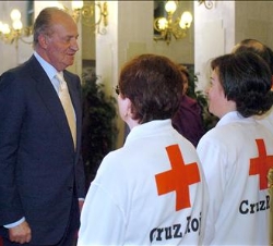 Su Majestad conversa con unos voluntarios de Cruz Roja Española a su llegada al Teatro Principal