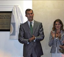 Sus Altezas Reales los Príncipes de Asturias junto a la placa conmemorativa de la inauguración de la nueva sede