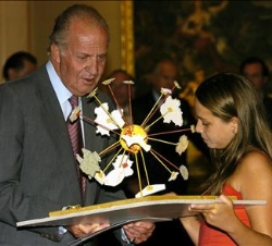 Don Juan Carlos examina el trabajo de una de las niñas ganadoras del concurso