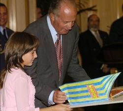 Una niña muestra su trabajo a Don Juan Carlos