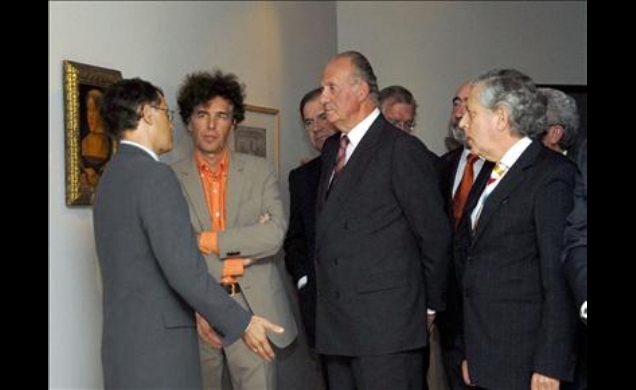 Don Juan Carlos atiende a las explicaciones de los comisarios de la muestra, Miguel Ángel Zalama y Paul Vandenbroeck